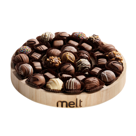 Dairy Chocolate Balls and Chocolates on Round Wooden Tray